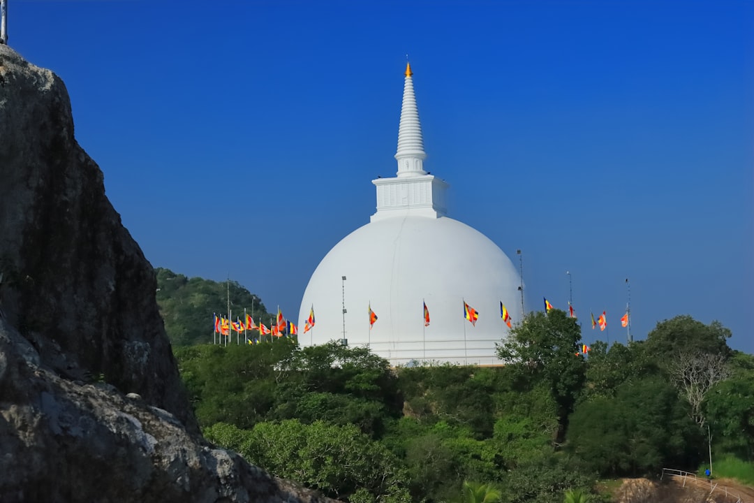 a large white building sitting on top of a lush green hillside